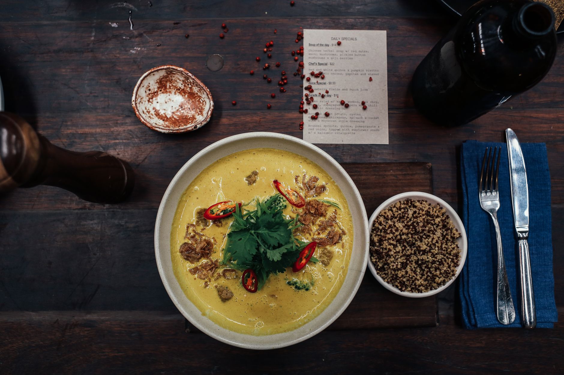 Delicious spicy curry soup with quinoa and fresh herbs served on a rustic table. — Understanding organic Pizza and inorganic